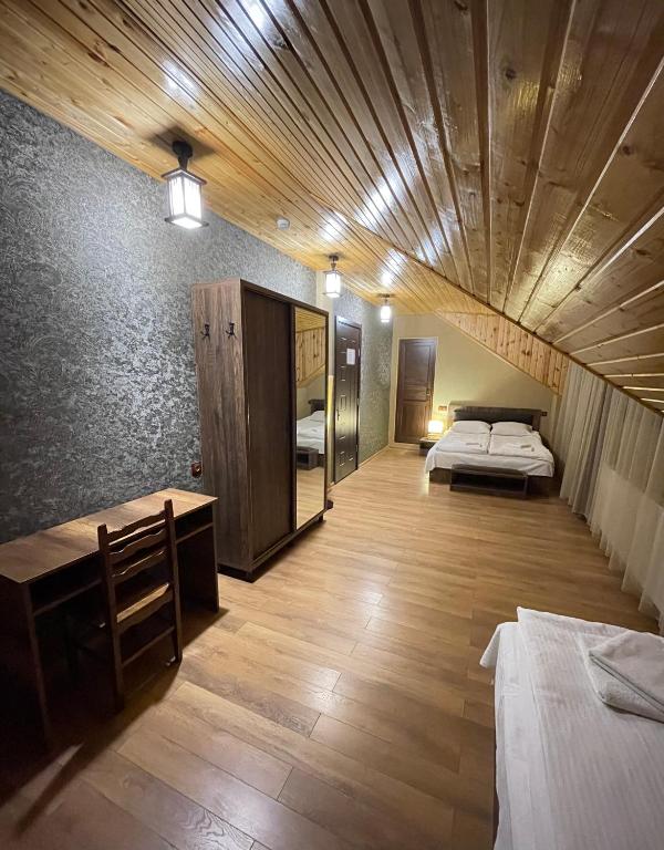 a room with two beds and a wooden ceiling at Hotel Elite House in Mestia