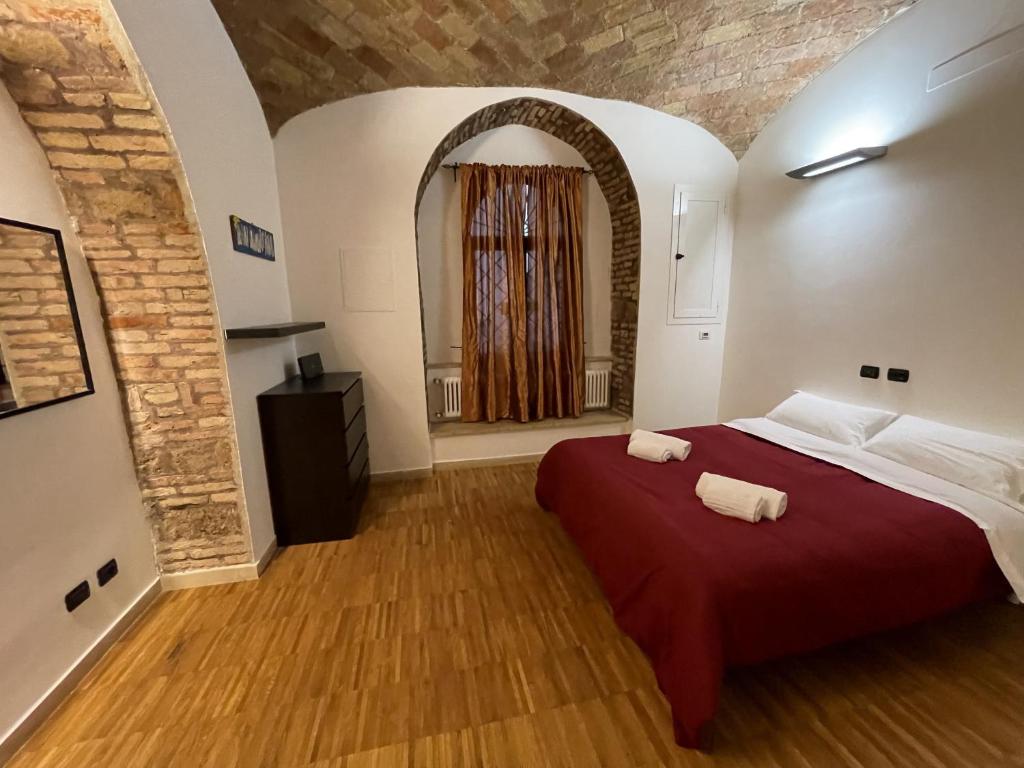 sypialnia z czerwonym łóżkiem i 2 ręcznikami w obiekcie Heart of San Lorenzo - La casa particular w Rzymie