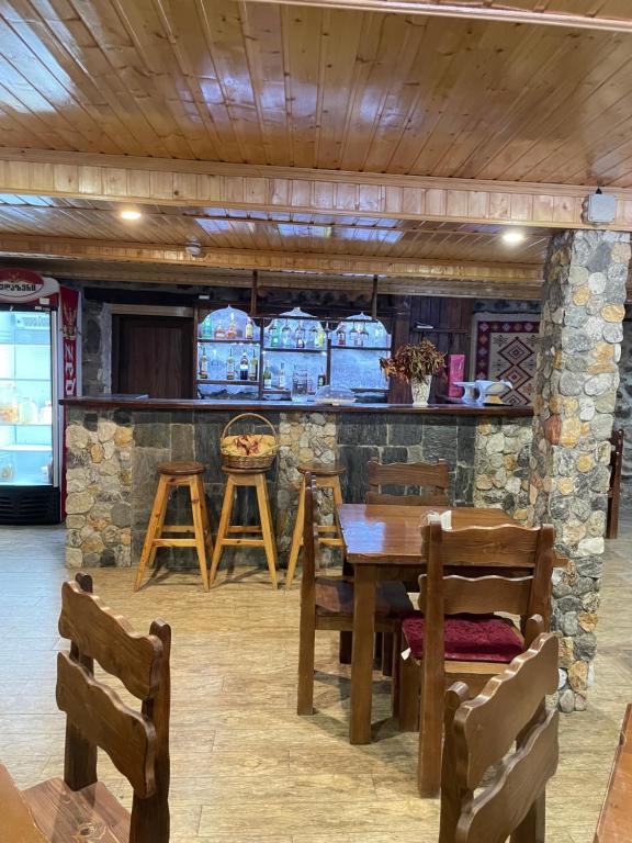 a dining room with a table and chairs and a bar at Hotel Elite House in Mestia
