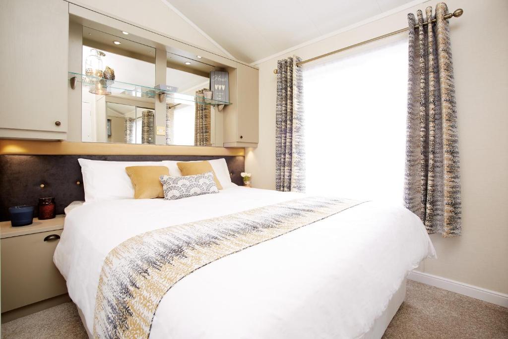 a bedroom with a large white bed and a window at JJs Lodge Azalea in York