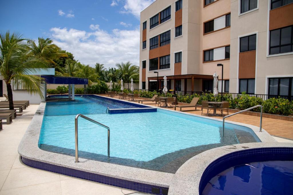 ein Schwimmbad vor einem Gebäude in der Unterkunft Flat em Guarajuba in Guarajuba