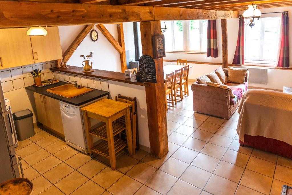 uma cozinha e sala de estar com uma mesa e um balcão em GITE AUTOMNE em Le Soulié