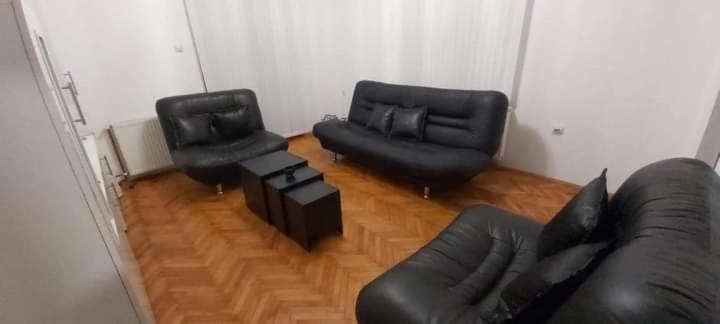 a living room with black leather chairs and a couch at Apartman Ivanović 5 in Soko Banja