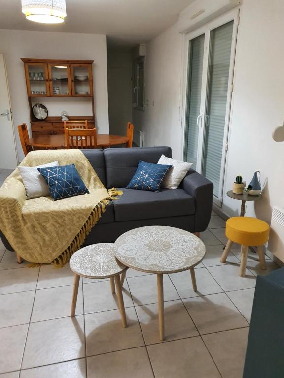 uma sala de estar com um sofá e uma mesa em l oiseau bleu em Cayeux-sur-Mer