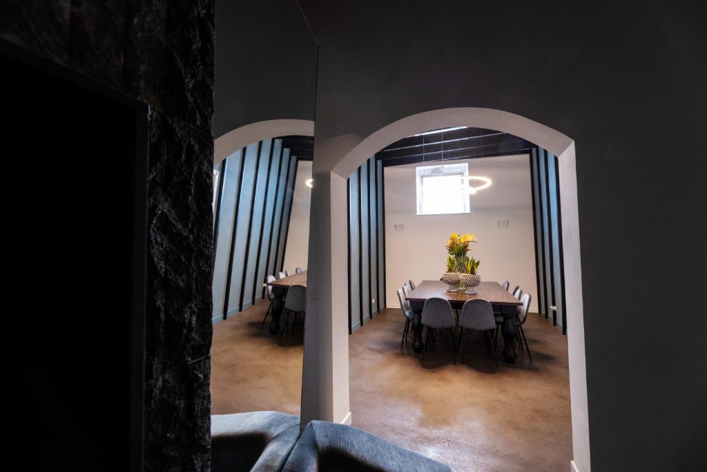uma sala de jantar com uma mesa com um vaso de flores em Riflessi Acireale Palace Suites em Acireale