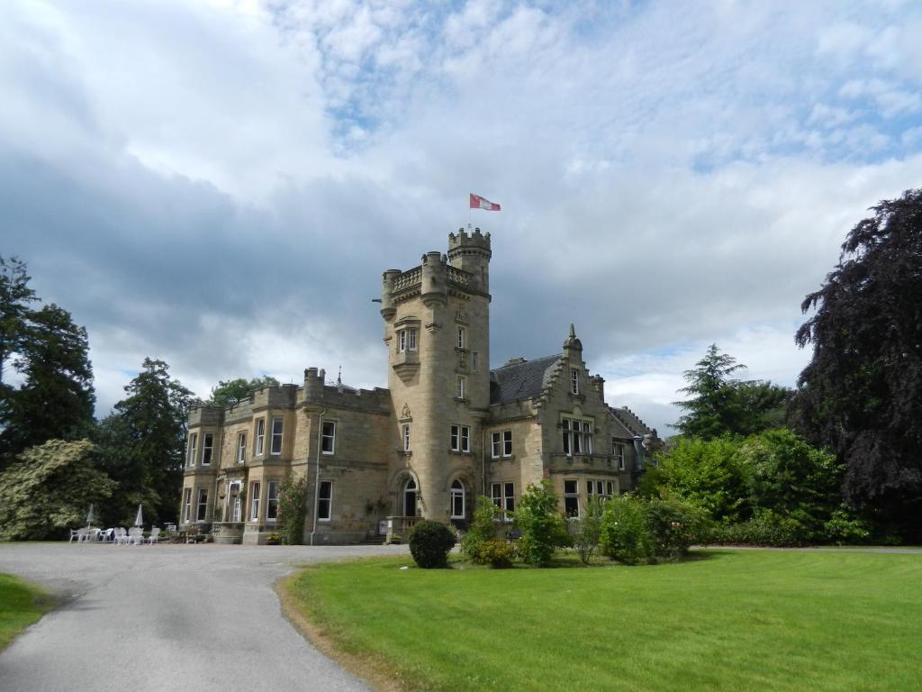 an old castle with a flag on top of it at Mansfield Castle Hotel in Tain