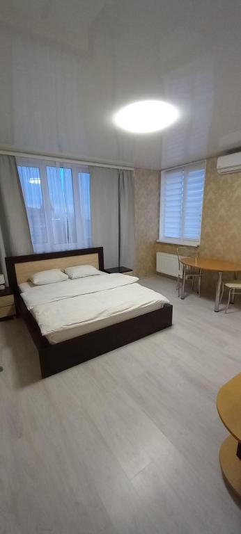 een slaapkamer met een groot bed en 2 ramen bij Квартал Авиа in Vyshneve