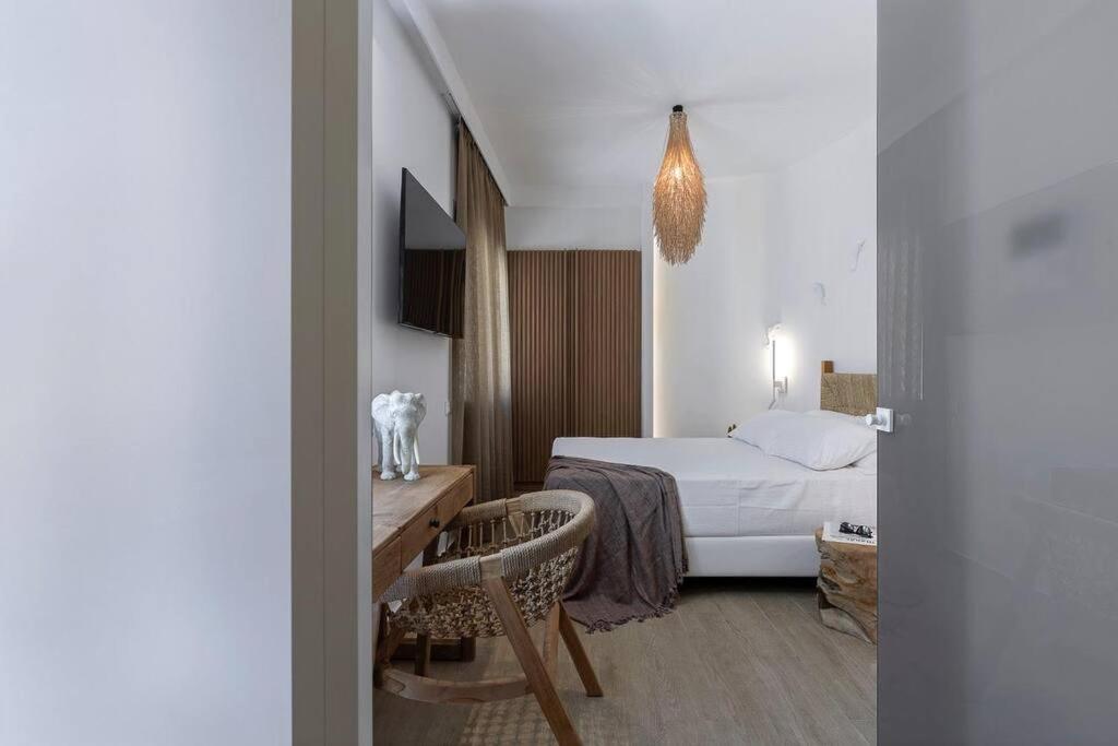 a hotel room with a bed and a table and chairs at Boho Sapiens Marina - Romantic Cave in Adamas