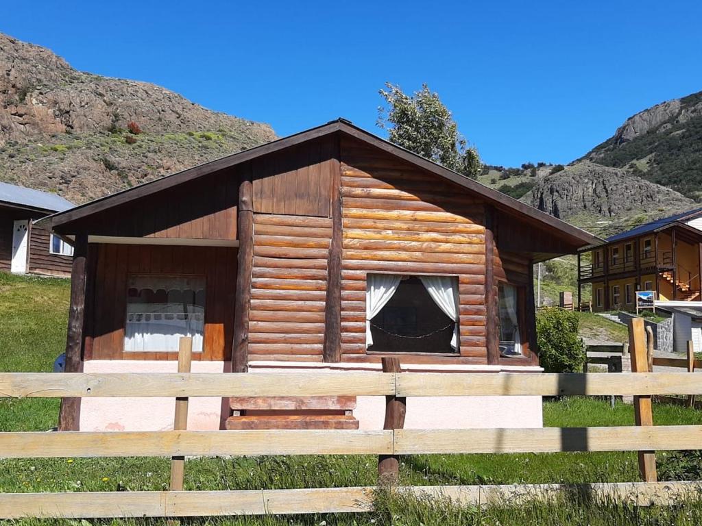 a log cabin with a fence in front of it at Complejo Las Maras in El Chalten