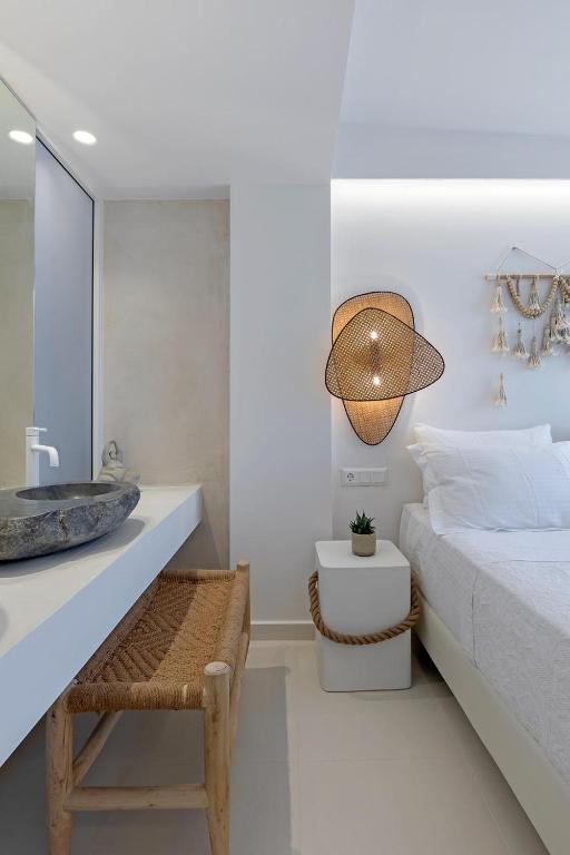 a bedroom with a bed and a sink and a table at Boho Sapiens Marina - Seagnature, Adamas Port in Adamantas