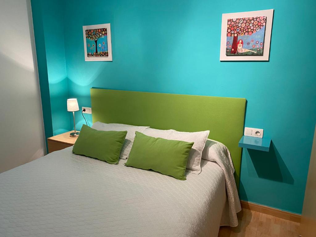 Schlafzimmer mit einem Bett mit grünen und blauen Wänden in der Unterkunft Apartamentos Alcañiz, Ana in Alcañiz