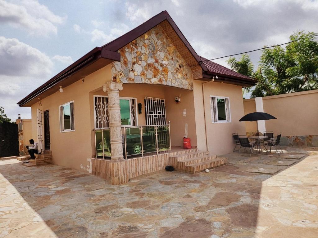 una casa con patio frente a ella en Janesis Holiday Homes, en Oyibi