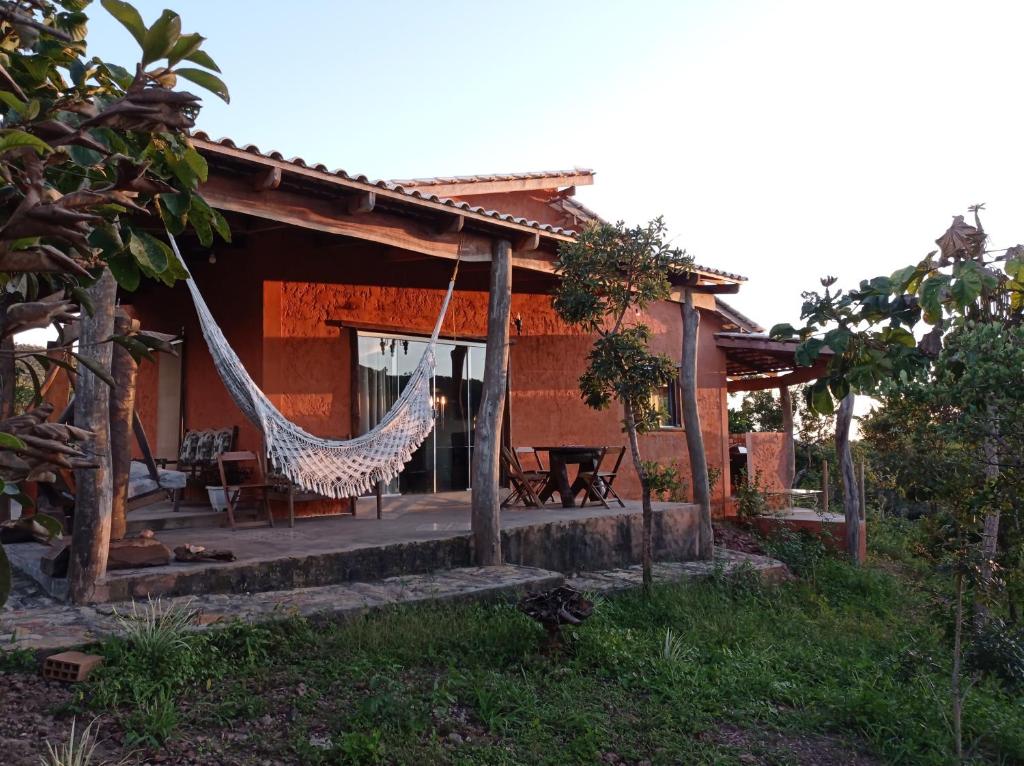 a house with a hammock in front of it at Casa Kali - O seu refúgio nas montanhas! in Sao Jorge