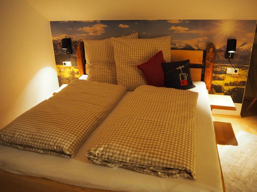 a bedroom with two beds with checkered sheets at Ferienwohnung Grüntenpanorama im Jägerwinkl Allgäu in Rettenberg