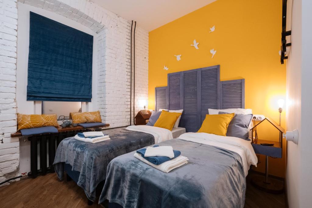 2 camas en una habitación con paredes amarillas en Titmouse Hotel, en Moscú