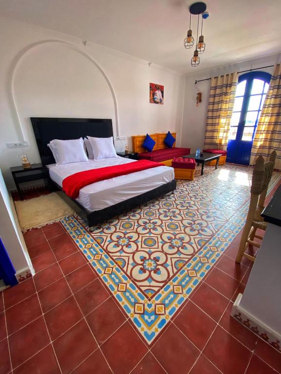 a hotel room with a bed and a rug at Dmina House in Asilah