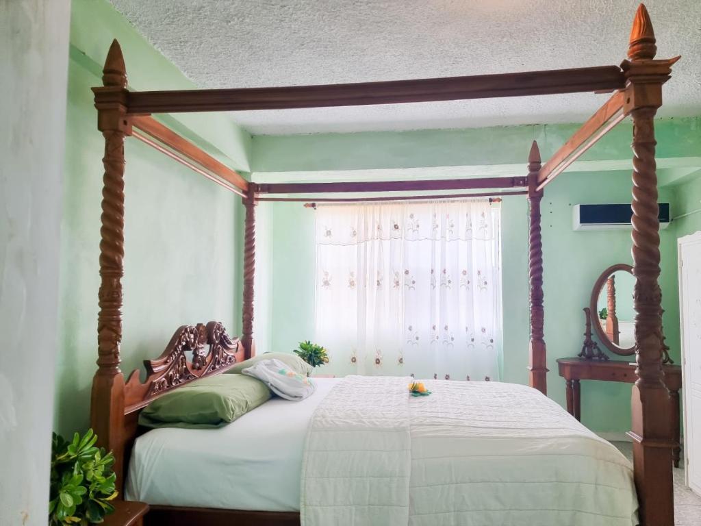 una camera da letto con letto a baldacchino e finestra di Belle View Apartment Villa - La Mar penthouse a Laborie