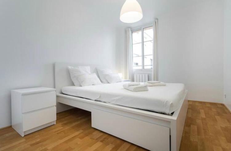 een witte slaapkamer met een wit bed en een raam bij BIG WHITE in Nice