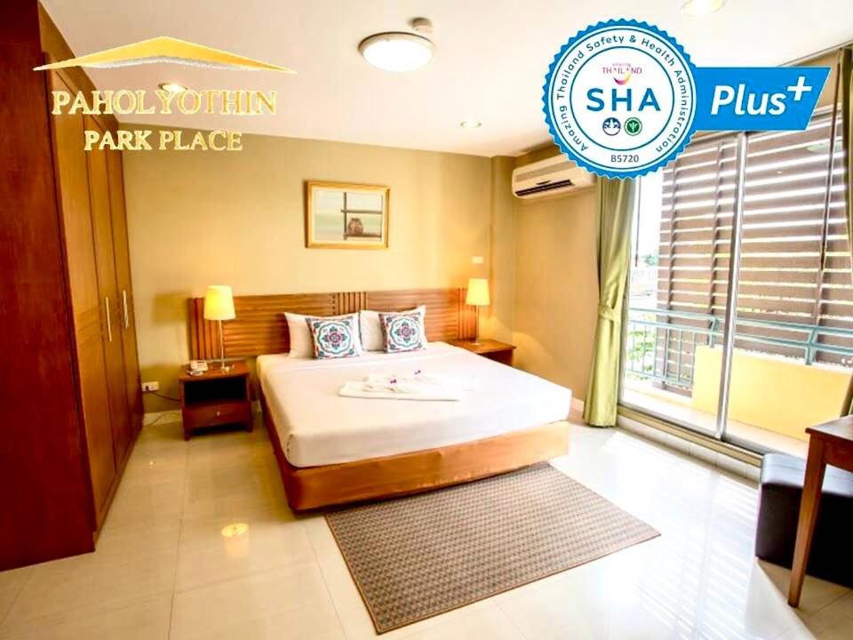 um quarto de hotel com uma cama e uma placa em Paholyothin Park Place em Bangkok