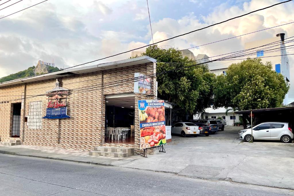 a brick building with a sign in a parking lot at Hotel Y Restaurante La Quinta in Cartagena de Indias