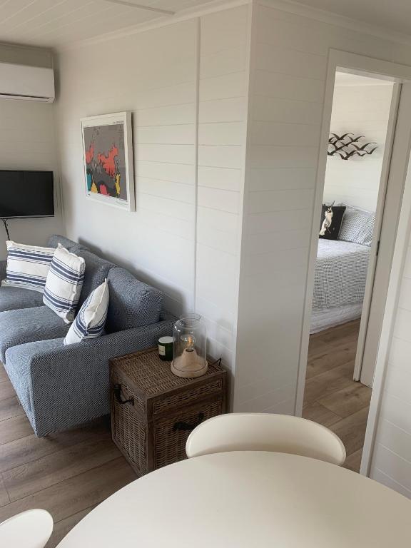 un soggiorno con divano e letto di 125 Church Bay Cabins a Oneroa