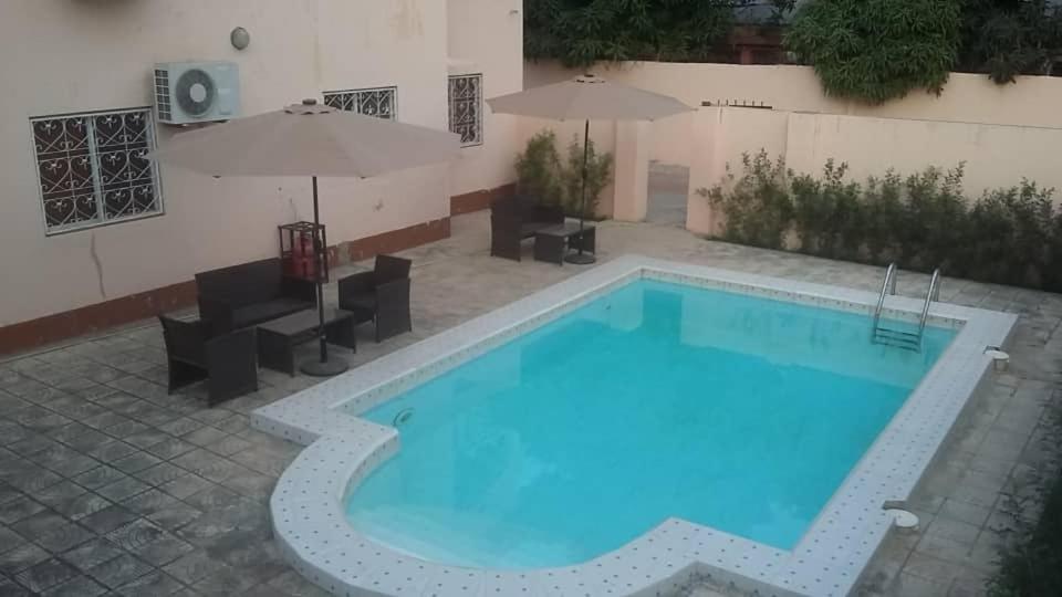 a large blue swimming pool next to a building at Gam Properties Guest House in Kololi