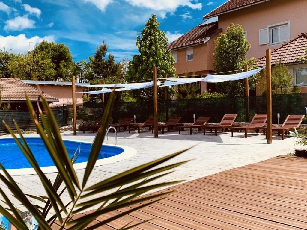 eine Terrasse mit Stühlen, einem Pool und einem Zaun in der Unterkunft Apartments San - with pool; in Rakovica