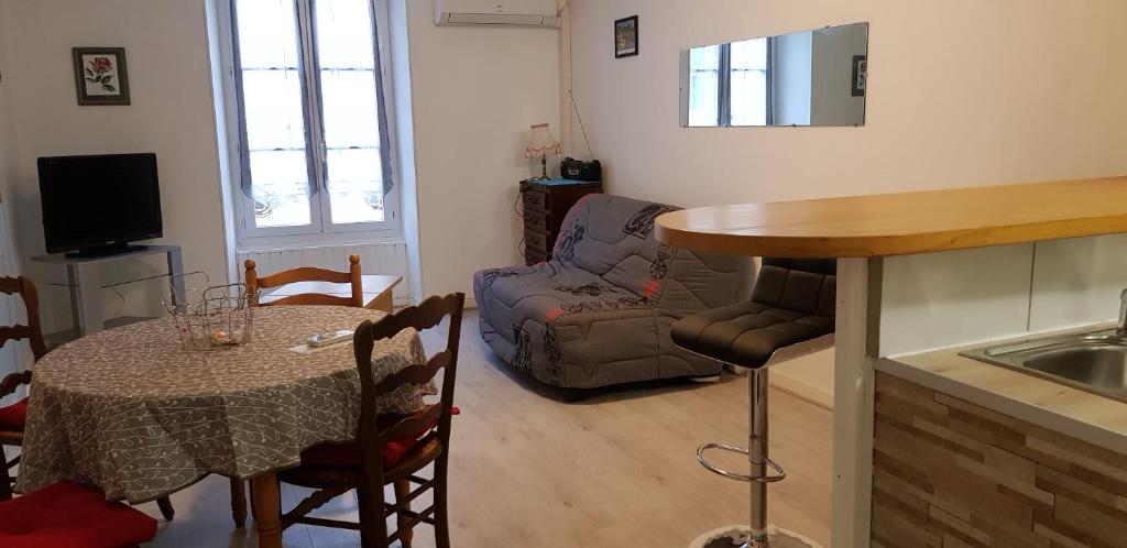 een keuken en een woonkamer met een tafel en een bank bij Centre ville Le Blanc Ville Basse in Le Blanc
