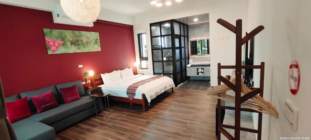 a hotel room with a bed and a couch at 嚨口十二之一民宿Longcall 12-1 in Jinning