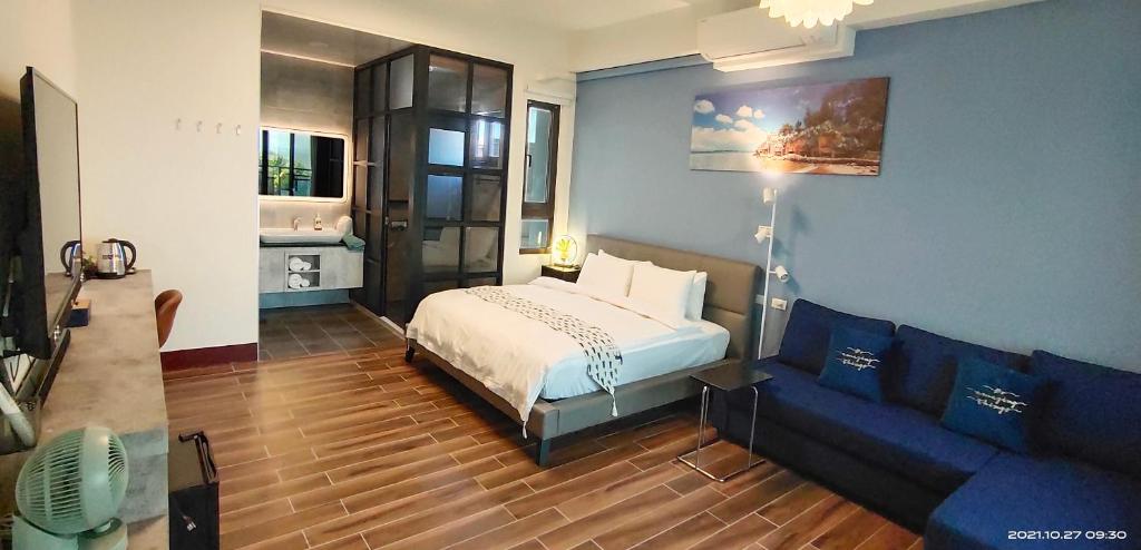 ein Schlafzimmer mit einem Bett und einem Sofa in der Unterkunft 嚨口十二之一民宿Longcall 12-1 in Jinning