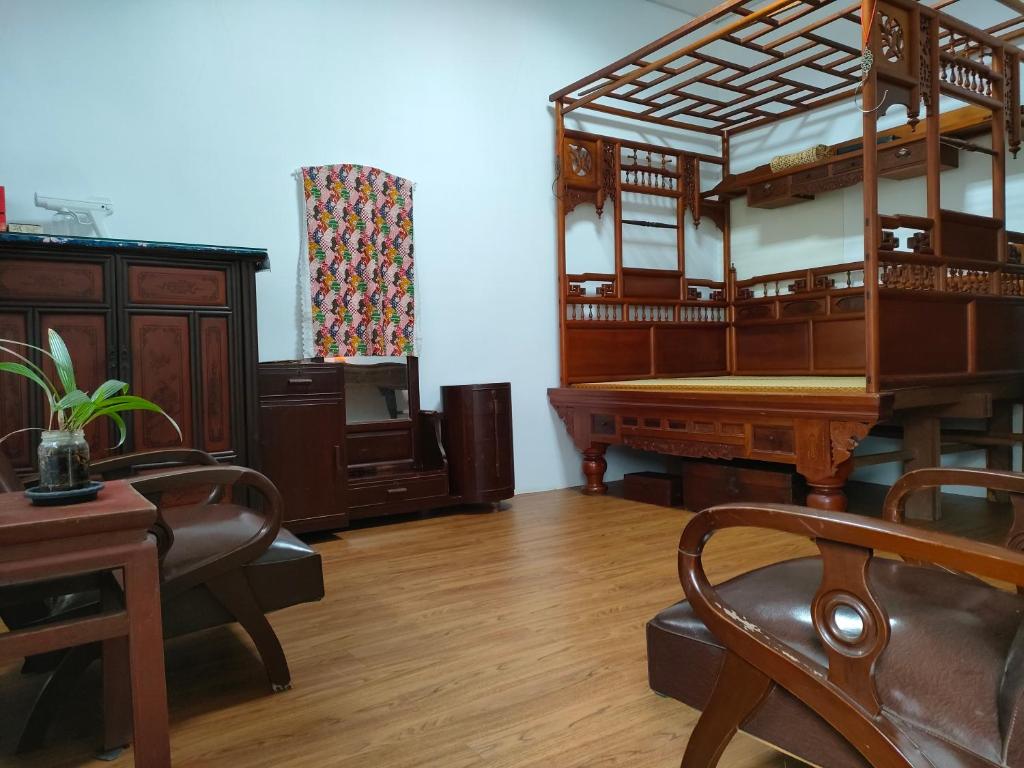 een kamer met een bed, een bureau en een piano bij 北斗合法古厝民宿 in Beidou