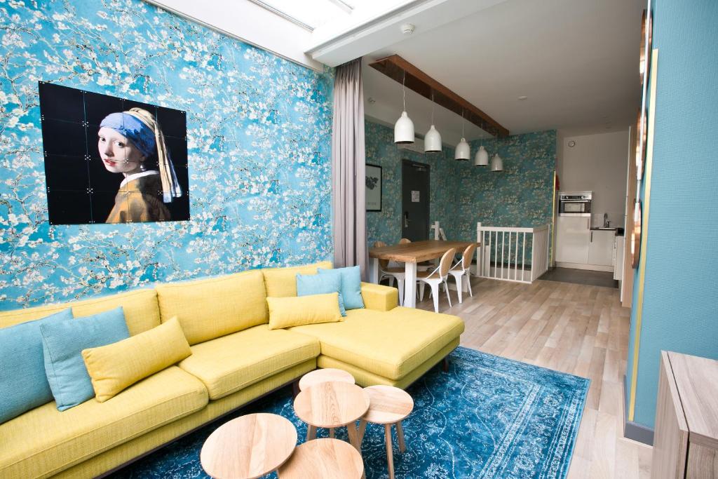 sala de estar con sofá amarillo y pared azul en Cityden Museumkwartier en Ámsterdam