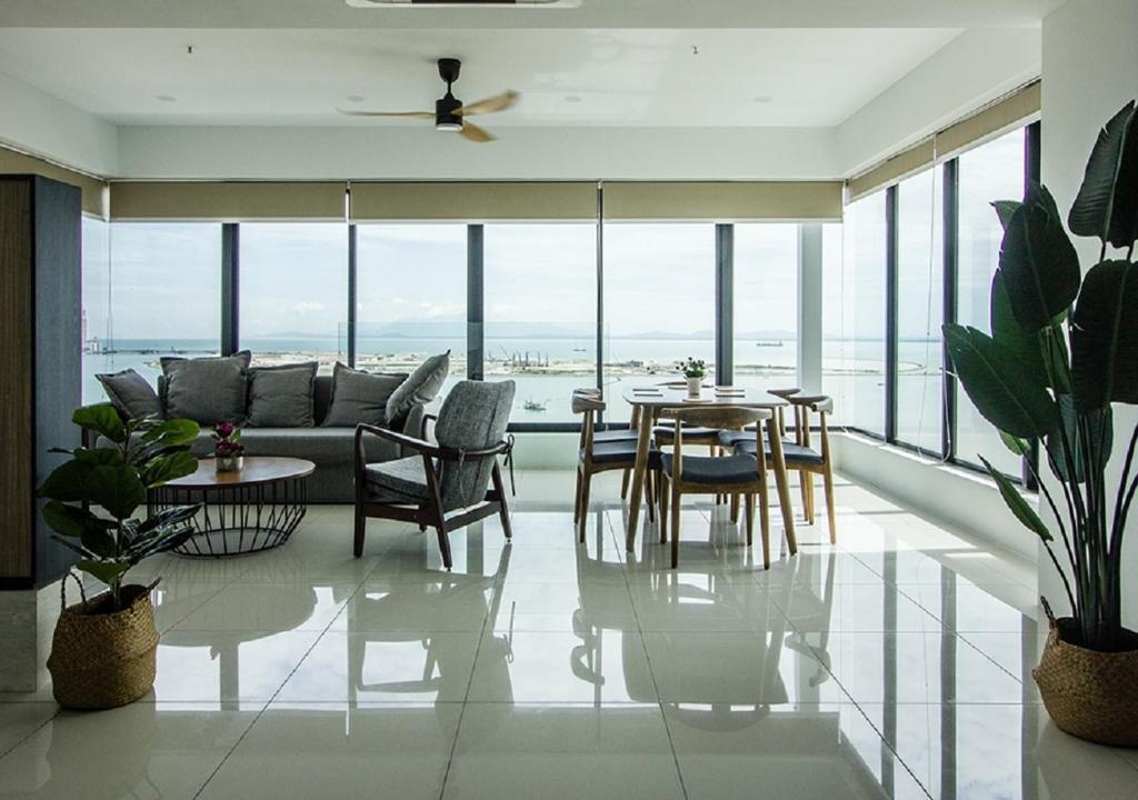 een woonkamer met een bank en een tafel en stoelen bij Rumahku Gurney with 270 degree Sea View in George Town