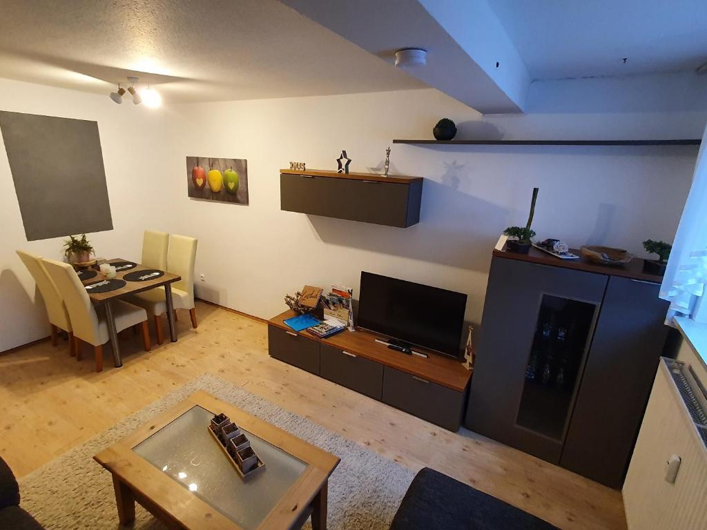 a living room with a television and a table at Apartment Anke in Braunlage
