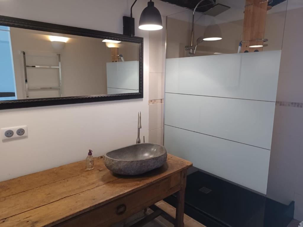 La salle de bains est pourvue d'un lavabo en pierre sur une table en bois. dans l'établissement Domaine l'Esprit d'Antan, à Villeneuve-sur-Lot