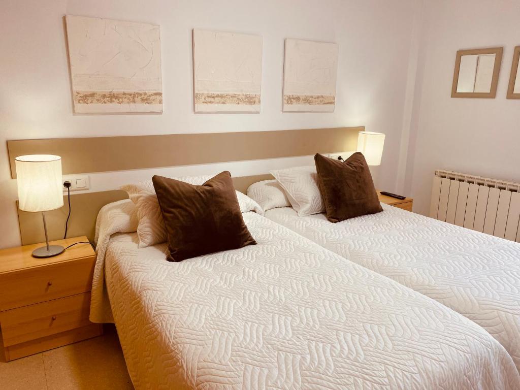 a bedroom with a bed with two pillows on it at Apartamentos Alcañiz, Blanca in Alcañiz