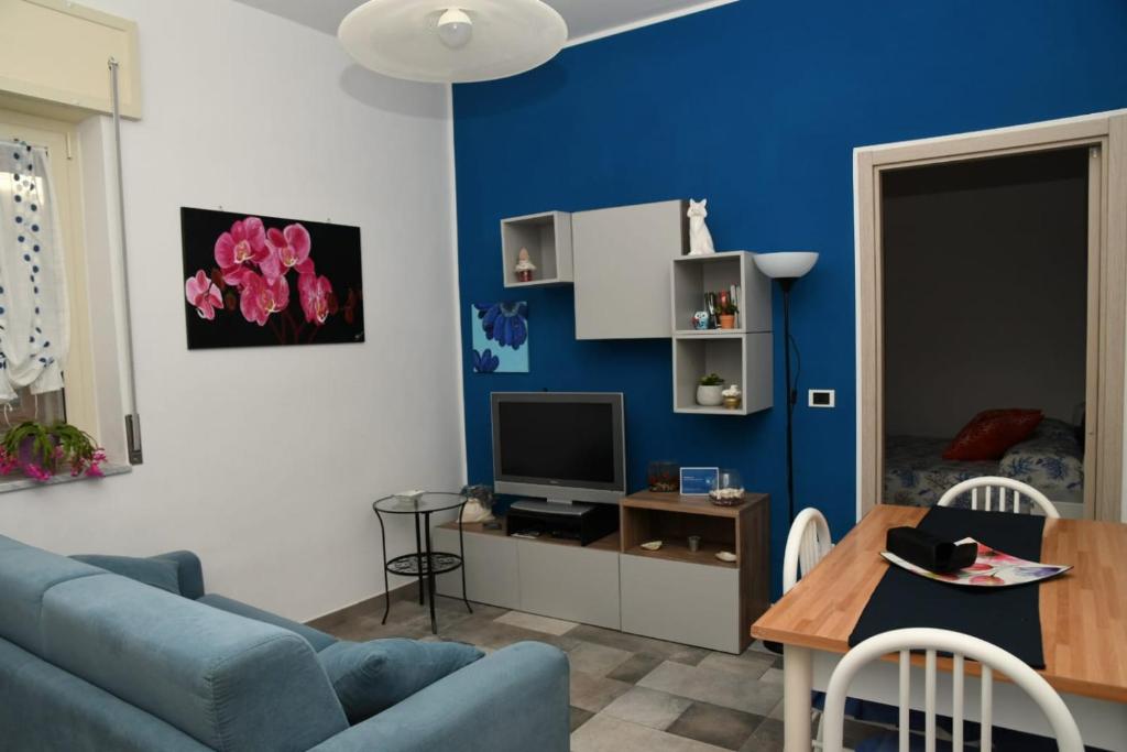 sala de estar con pared de acento azul en La Casa di Ermelinda, en Sapri