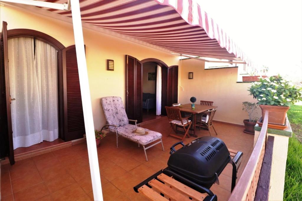 a patio with a grill and a table with a chair at Apartment with large relax terrace and top equipment in Costa Del Silencio