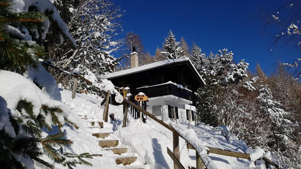 une maison recouverte de neige avec des escaliers devant dans l'établissement Charming chalet with panoramic view and private garage in Gruyère, à Gruyères