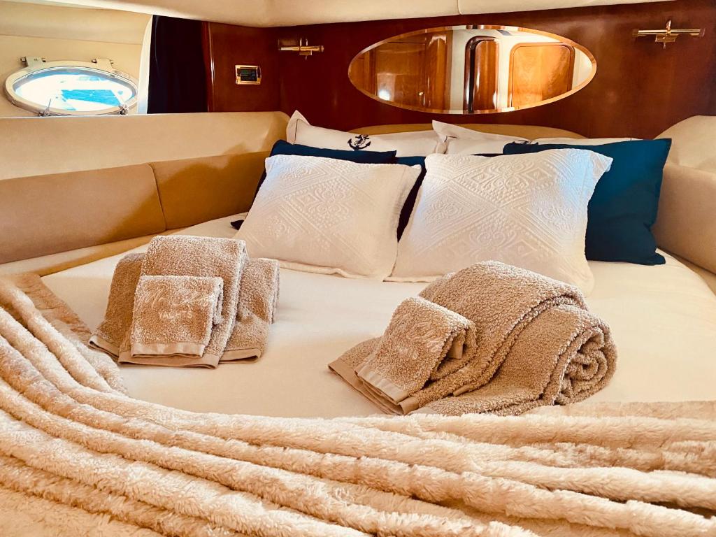 a bed with pillows and towels on it at Mr. Cliff Yachts in Quarteira