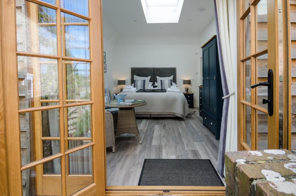 a door leading to a bedroom with a bed at Lavender Lodge in Arundel