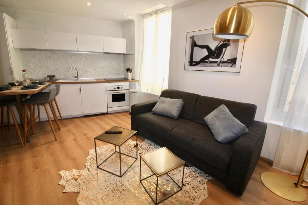 a living room with a couch and a kitchen at Lovely Apartment Heart of Golden Square Fiber Wifi in Nice