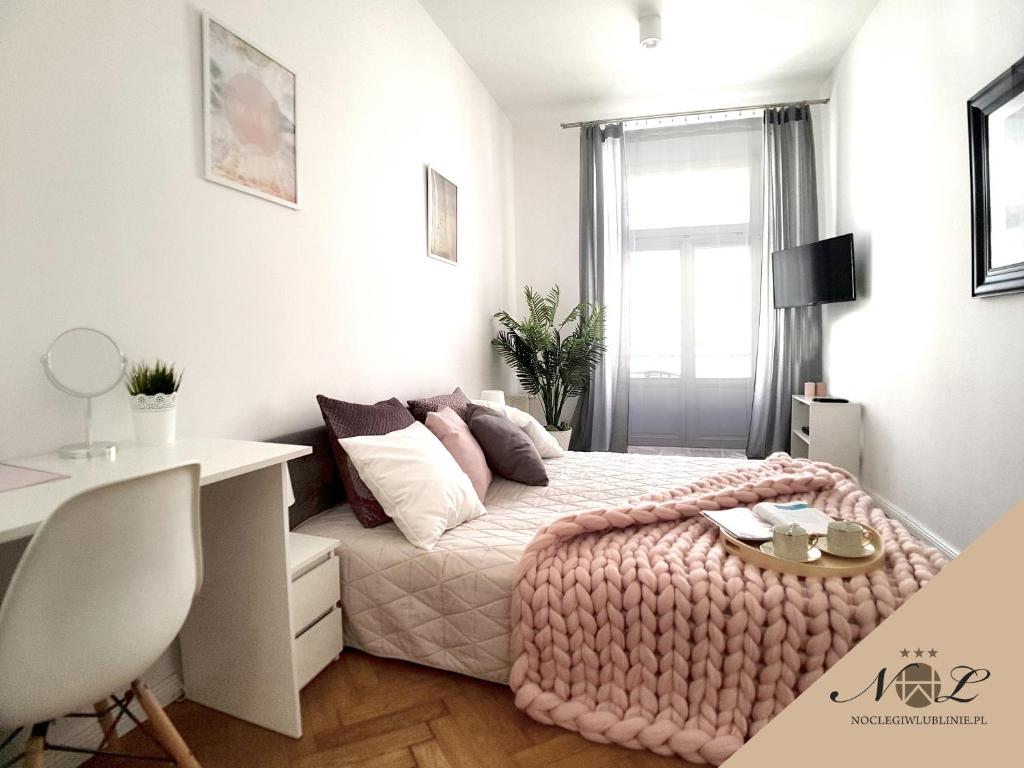 1 dormitorio con 1 cama con manta rosa en Apartament Peowiaków Queens en Lublin