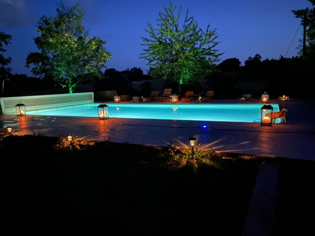a swimming pool lit up at night at Manoir du Suquet in Bardou