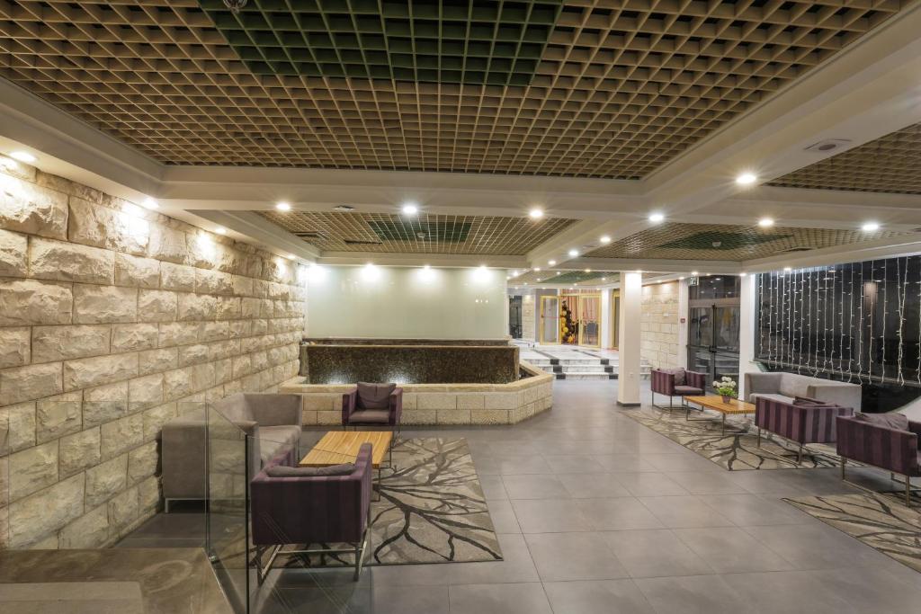 a lobby of a hotel with a stone wall at Tabar Hotel in Nazareth