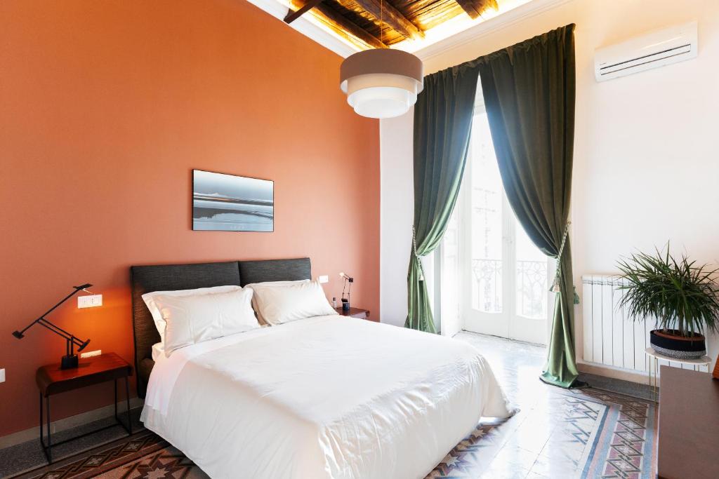 una camera da letto con una parete arancione e un letto bianco di SUITE CASA FANZAGO a Napoli