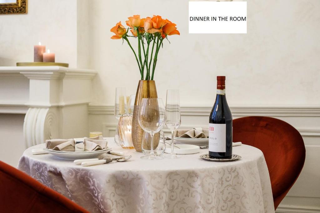 une table avec une bouteille de vin et un vase de fleurs dans l'établissement B&B Augusto, à Bruges