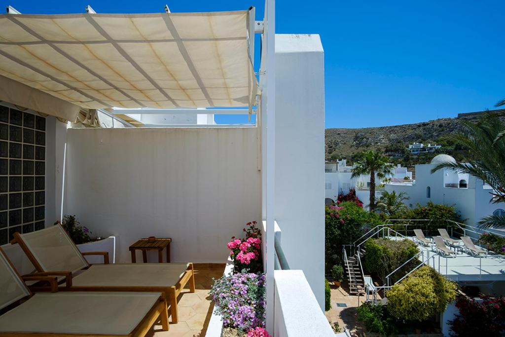 a patio with a table and chairs on a balcony at miKasa Agua Amarga & SPA in Agua Amarga