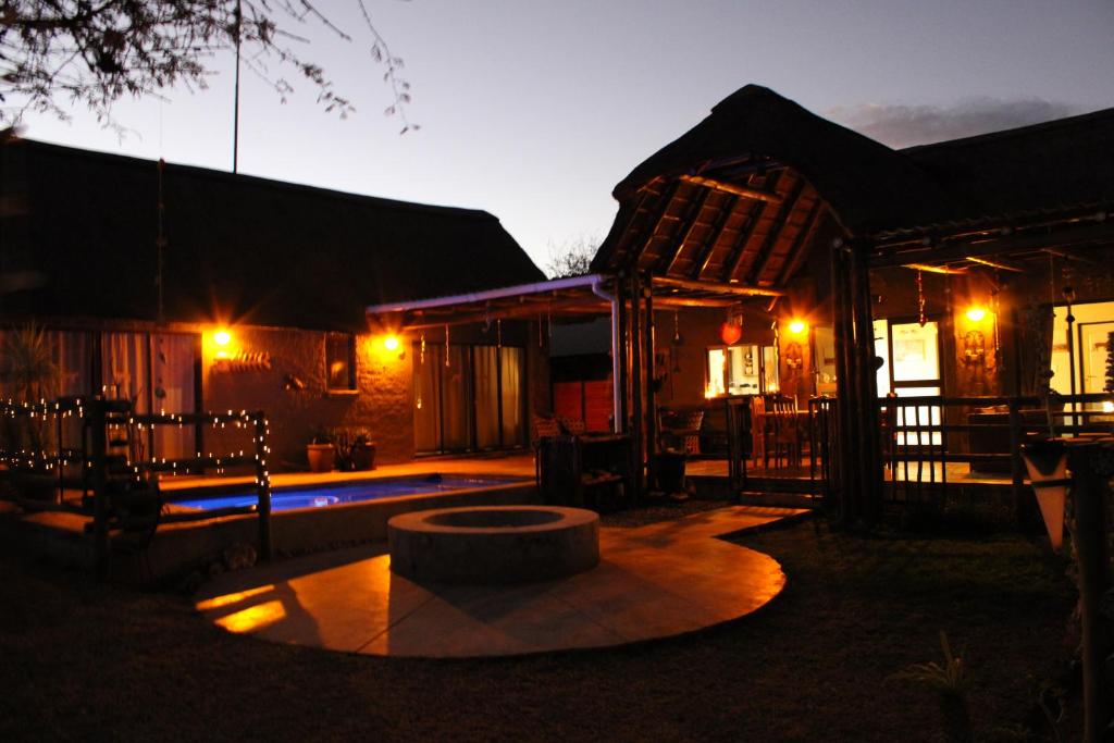una casa con una fuente frente a ella por la noche en Thuhlo lodge, en Hoedspruit