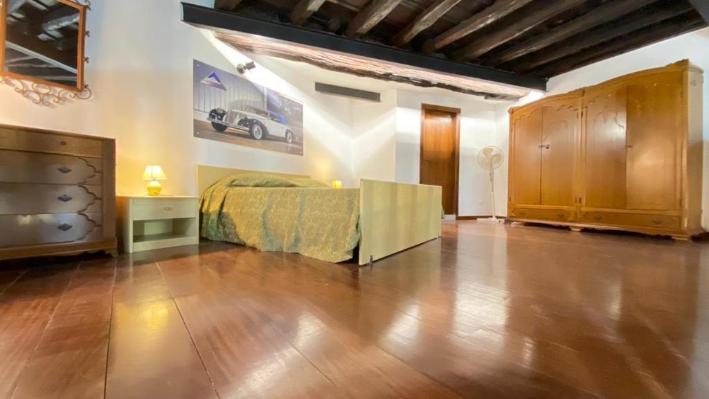 1 dormitorio con 1 cama y suelo de madera en Casa Monviso Le fuoriserie, en Palermo